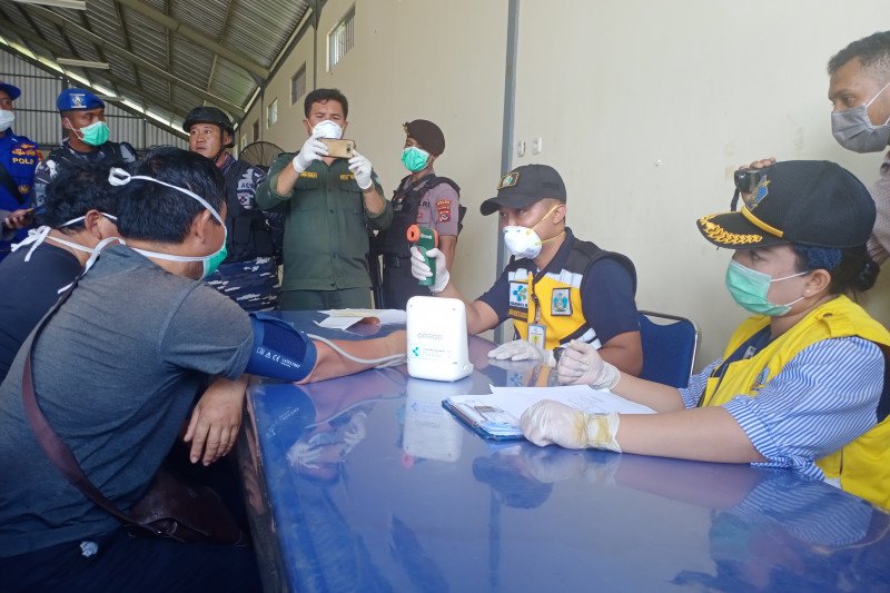 Petugas kesehatan dari KKP Kupang memeriksa suhu tubuh WNA China