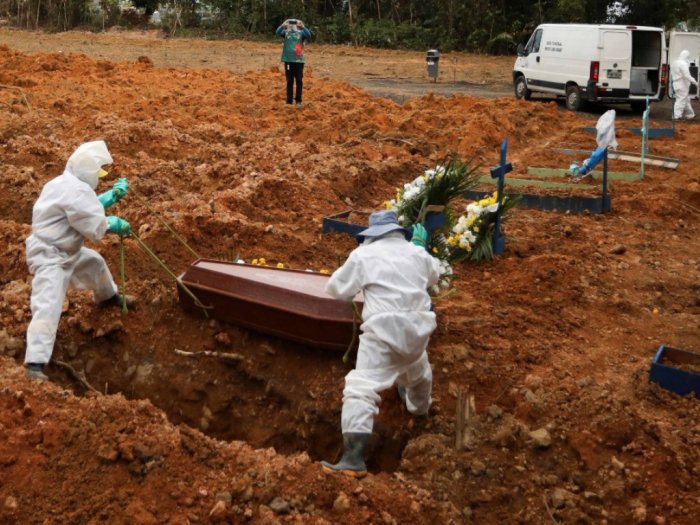 Penggali kuburan menggunakan alat pelindung diri saat bersiap untuk menguburkan korban COVID-19